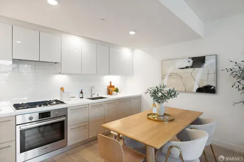 a kitchen with stainless steel appliances kitchen island granite countertop a dining table and chairs in it