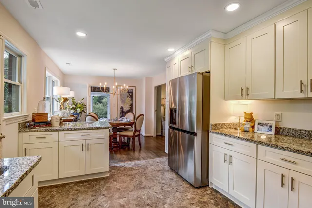 a kitchen with stainless steel appliances granite countertop a refrigerator and a stove top oven