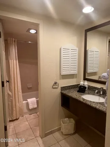a bathroom with a granite countertop sink a toilet a mirror and shower