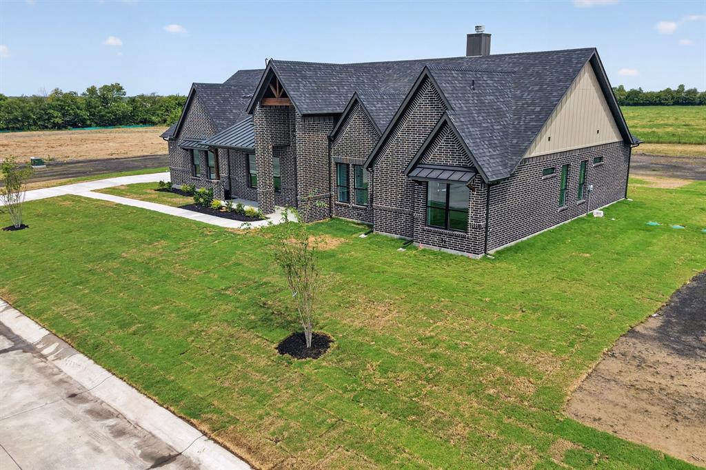 5410 Sunset Road Caddo Mills, TX 75135 - Photo 8 of 40 Brick facade, dark shingle roof, gabled architectural elements, multiple windows, and a paved walkway