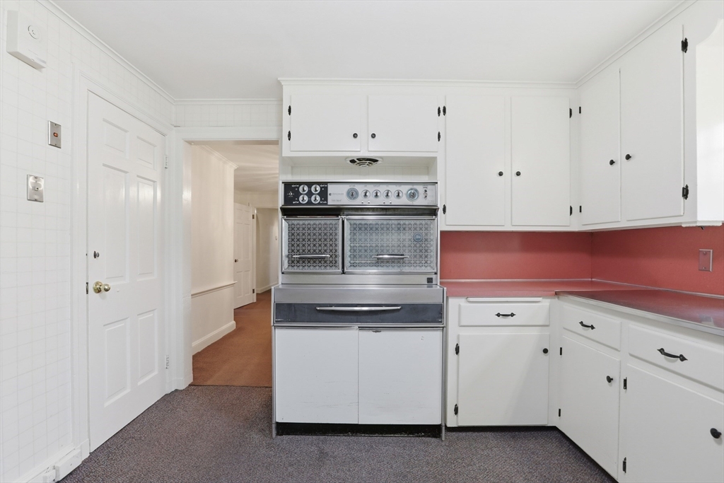 12 Canterbury Road Winchester, MA 01890 - Photo 14 of 33 a kitchen with granite countertop white cabinets and stainless steel appliances