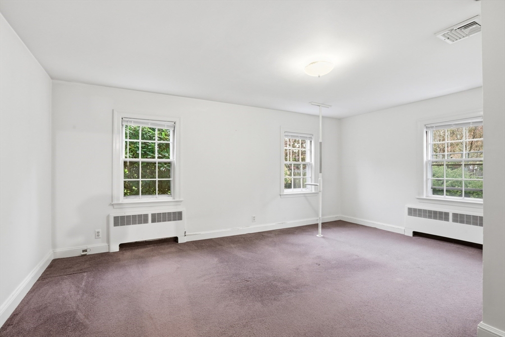 12 Canterbury Road Winchester, MA 01890 - Photo 25 of 33 an empty room with a fireplace and window