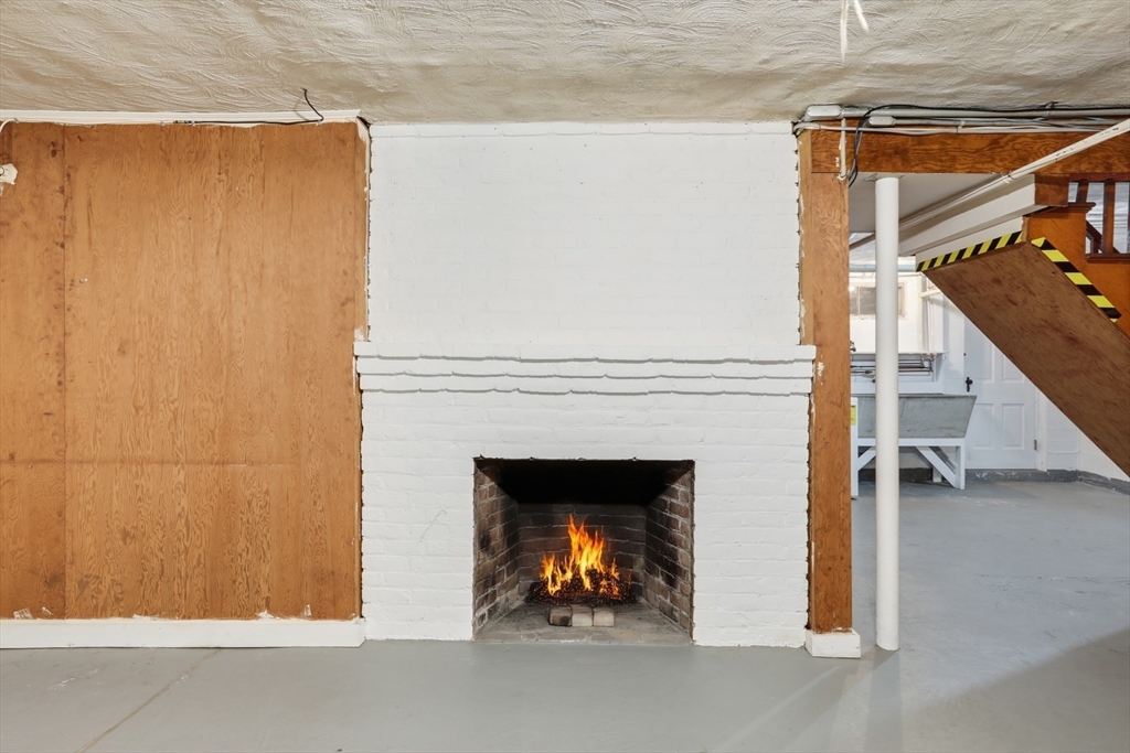 12 Canterbury Road Winchester, MA 01890 - Photo 30 of 33 a living room with a fireplace and a ceiling fan