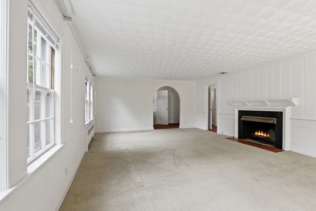 12 Canterbury Road Winchester, MA 01890 - Photo 8 of 33 a view of an empty room with a fireplace and a window