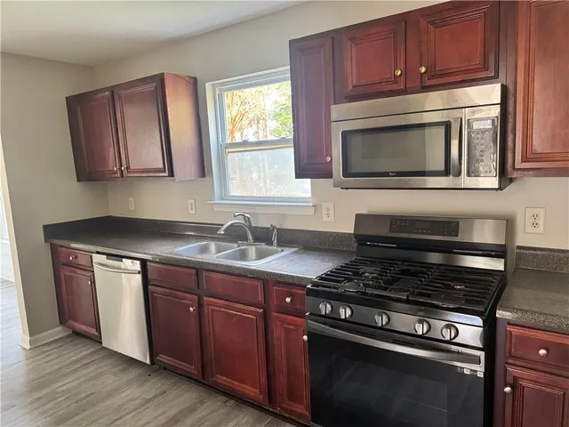 a kitchen with granite countertop wooden cabinets and stainless steel appliances