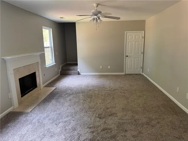 an empty room with windows and fireplace