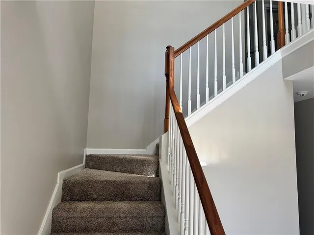 a view of staircase with wooden floor and white walls