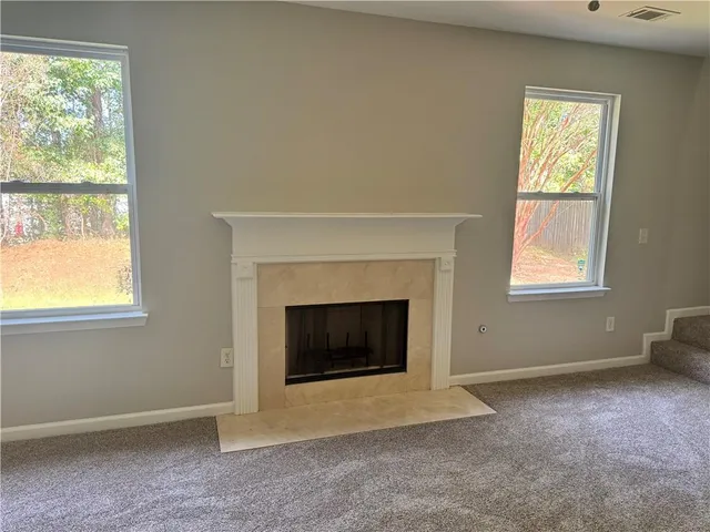 an empty room with a fireplace and windows
