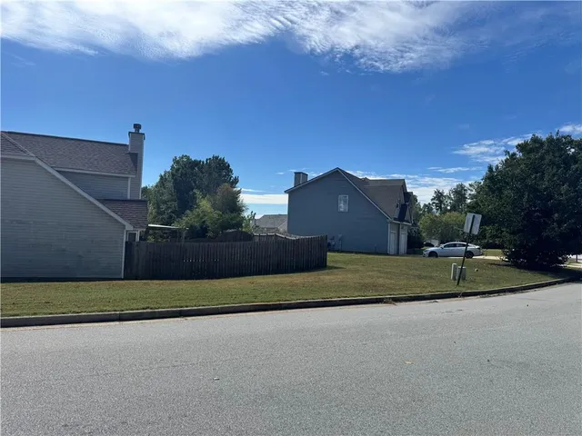 a view of a street with a house in the background
