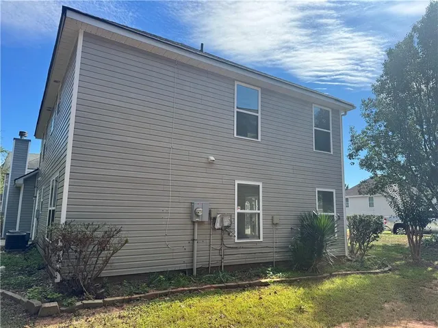a view of house with a large window and potted plants