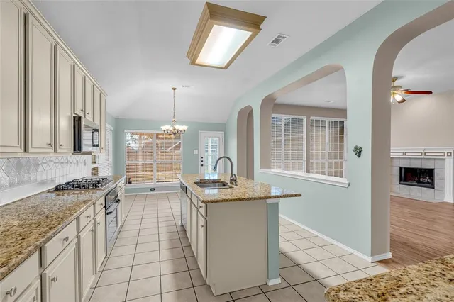 a kitchen with granite countertop a sink stove and cabinets