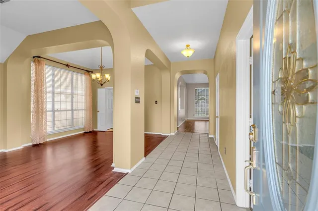 a view of a hallway with wooden floor and windows