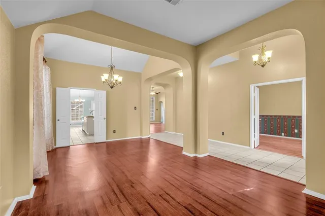 a view of a hallway with wooden floor and a bathroom