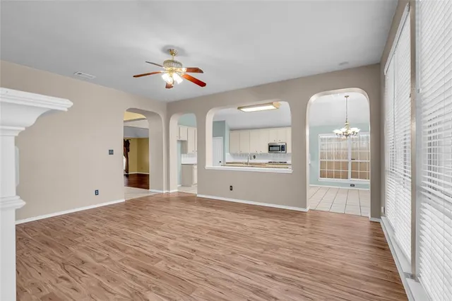 a view of an empty room with window and wooden floor