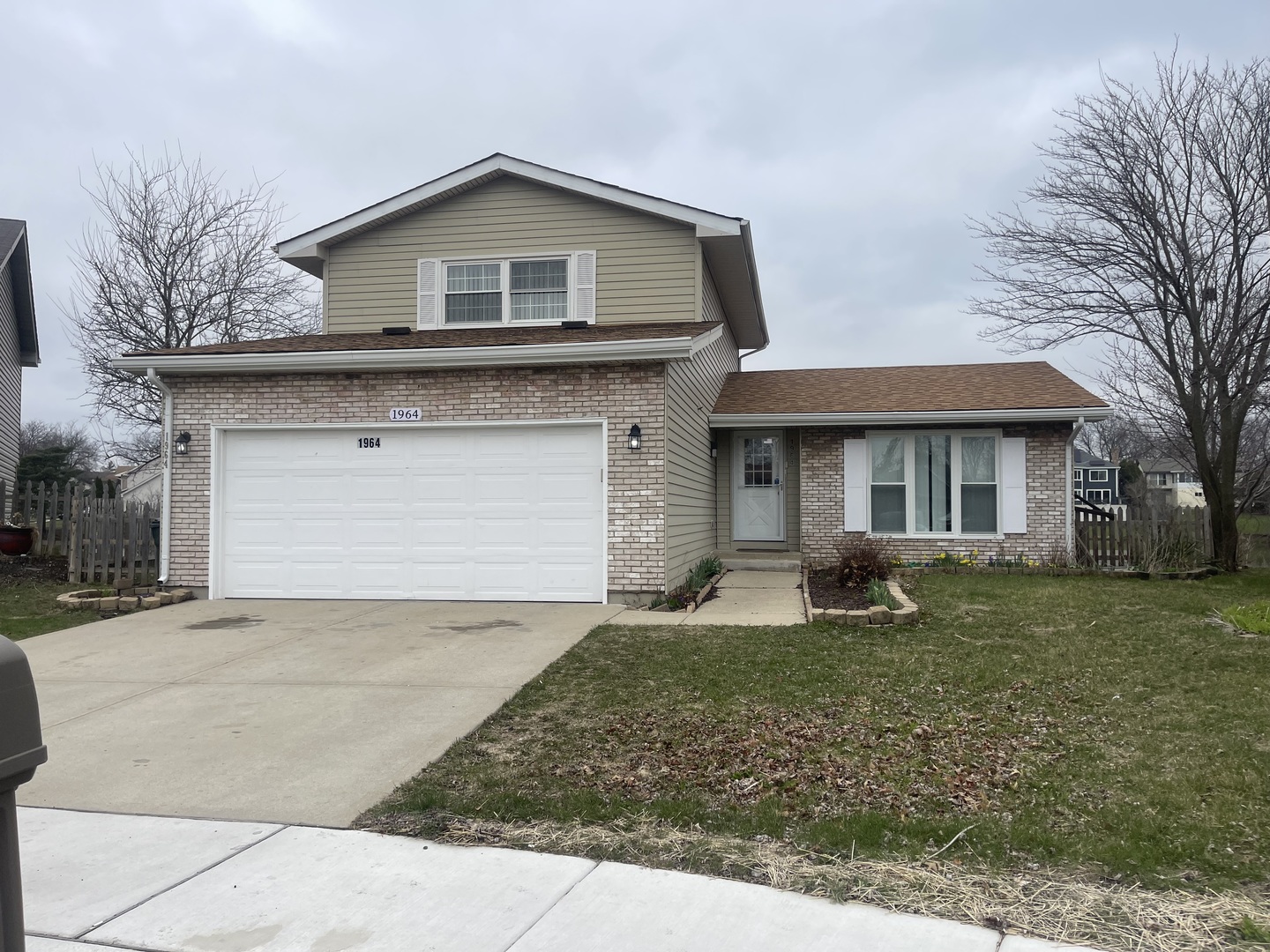a front view of a house with a yard garage and outdoor seating
