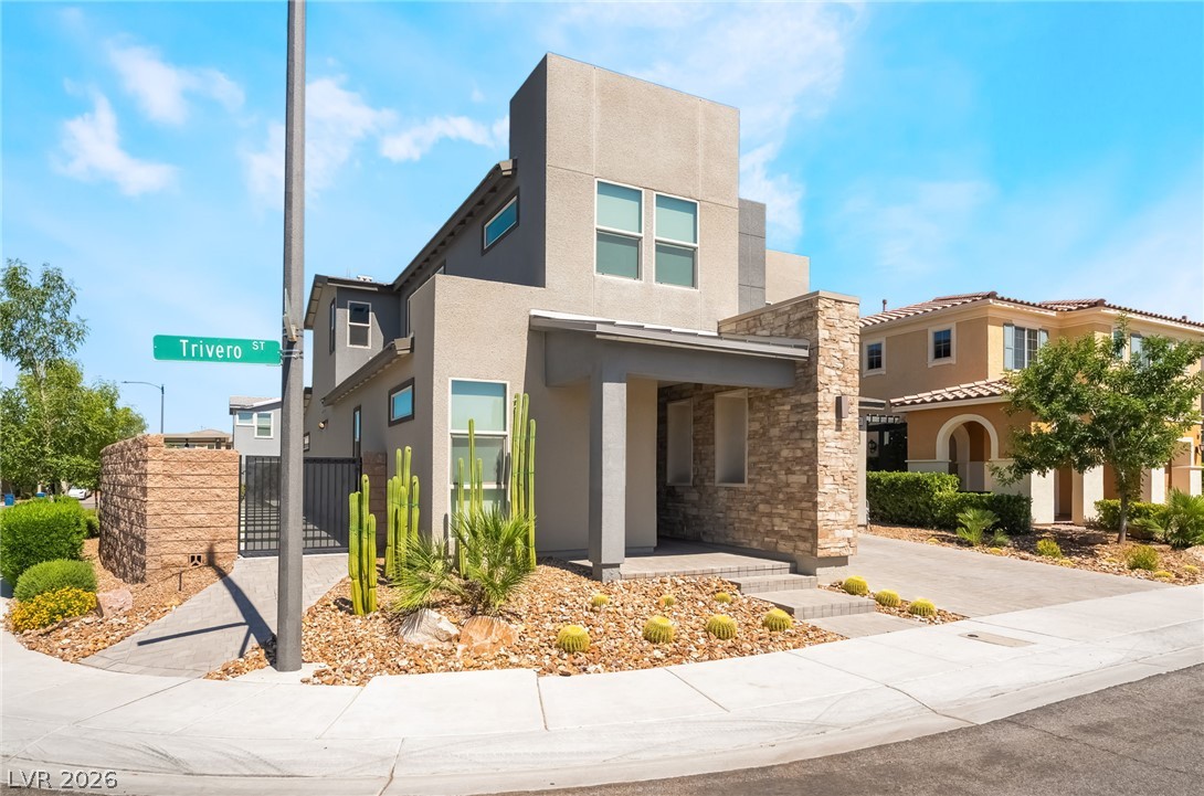 2166 Trivero Street Henderson, NV 89044 - Photo 2 of 61 A modern facade with striking stone accents and minimalist desert landscaping creates inviting curb appeal.