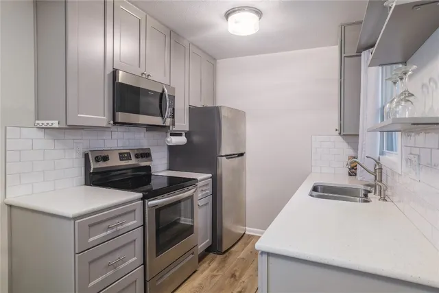 a kitchen with stainless steel appliances a stove microwave and refrigerator