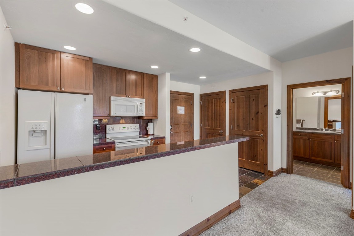34 Highfield Trail, Unit 209 Breckenridge, CO 80424 - Photo 18 of 24 a large kitchen with stainless steel appliances a large counter top a refrigerator and cabinets