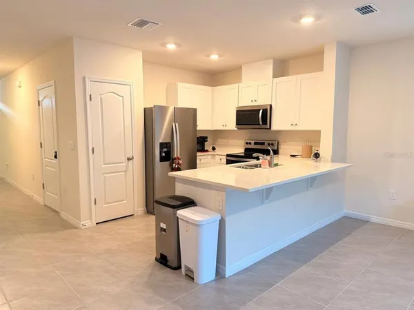 a kitchen with stainless steel appliances a refrigerator a sink a stove top oven and a refrigerator