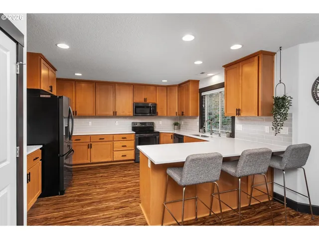 a kitchen with stainless steel appliances kitchen island granite countertop a refrigerator and microwave