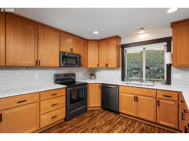 a kitchen with granite countertop cabinets stainless steel appliances and a sink