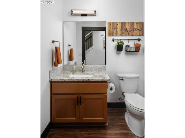 a bathroom with a granite countertop toilet sink and mirror