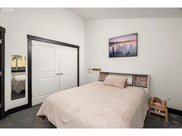 a bedroom with a large bed and a painting on the wall