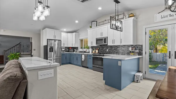 a kitchen with stainless steel appliances kitchen island granite countertop a stove refrigerator and cabinets