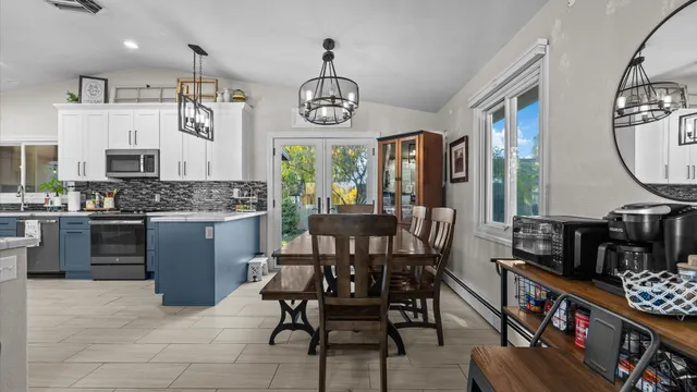a view of a dining room with furniture a chandelier and wooden floor
