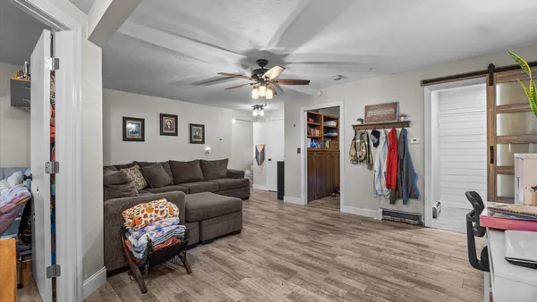 a living room with furniture a ceiling fan and a window