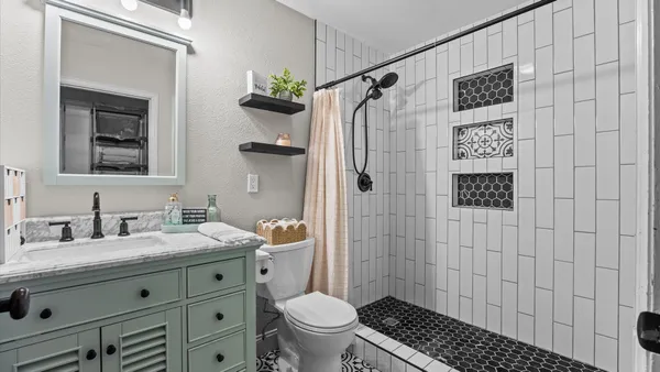 a bathroom with a granite countertop sink toilet and shower