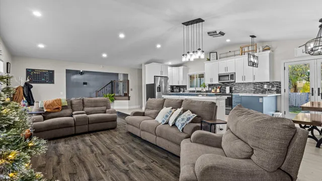 a living room with furniture and a view of kitchen