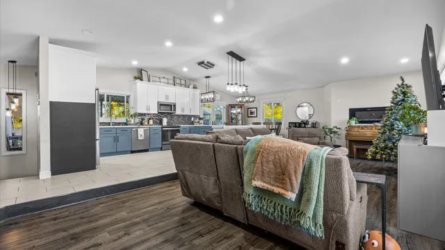 a living room with stainless steel appliances kitchen island granite countertop furniture wooden floor and a view of kitchen