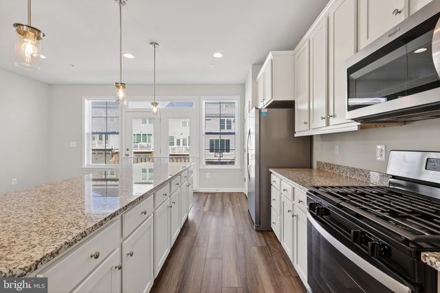 a kitchen with stainless steel appliances granite countertop a stove and a microwave