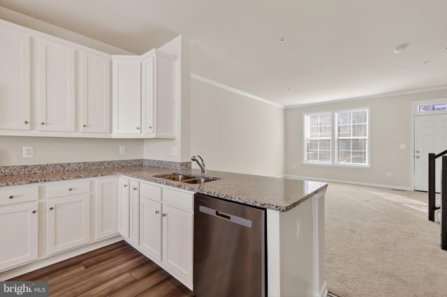 a kitchen with granite countertop white cabinets and a sink