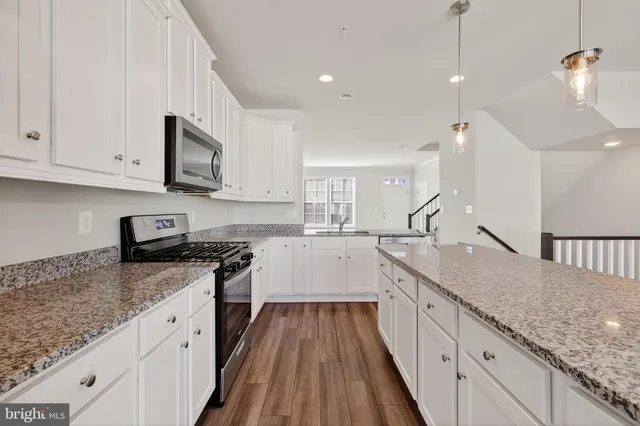 a large kitchen with stainless steel appliances granite countertop a stove sink and cabinets