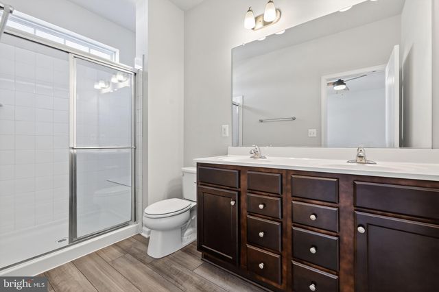 a bathroom with a double vanity sink toilet and a mirror