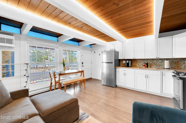 a kitchen with a table chairs refrigerator and couch