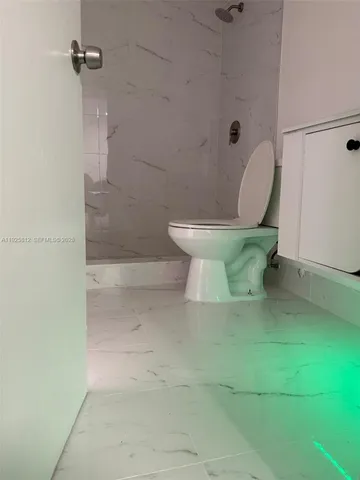 a white toilet sitting next to a bathroom