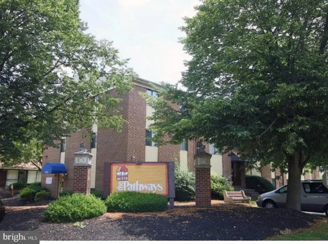 a sign board with buildings in the background