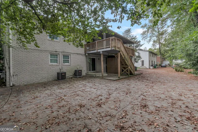 a view of a house with a yard and large tree