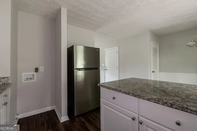 a kitchen with a refrigerator and a stove top oven