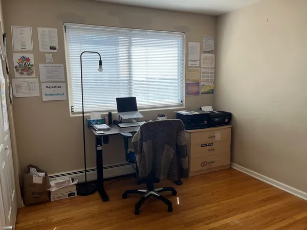 a view of a workspace with furniture and a window