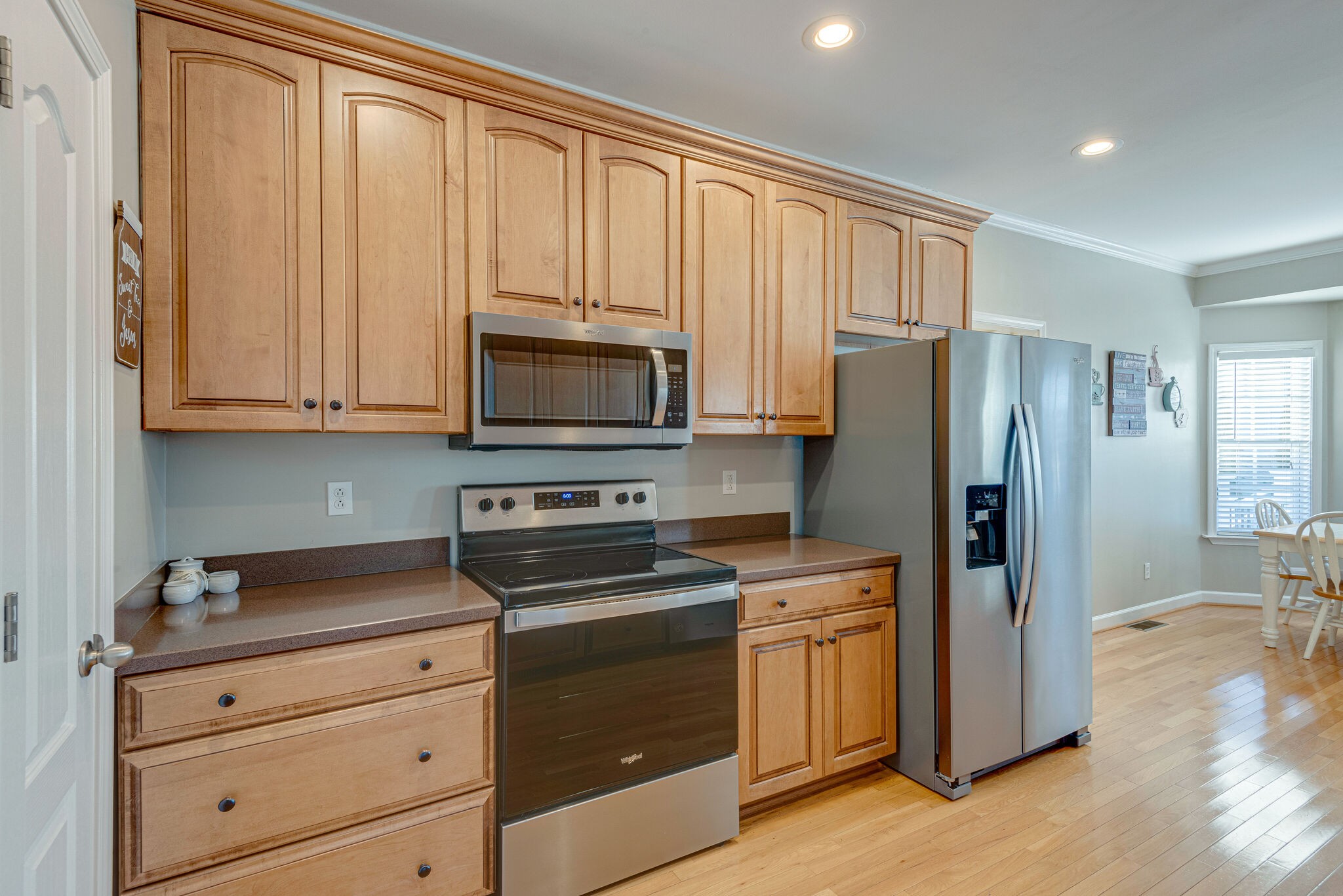 1686 Porter Road Bon Aqua, TN 37025 - Photo 13 of 28 a kitchen with granite countertop white cabinets stainless steel appliances and wooden floor