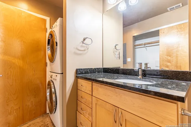 a bathroom with a granite countertop sink and a mirror