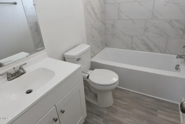 a white toilet sitting next to a bath tub