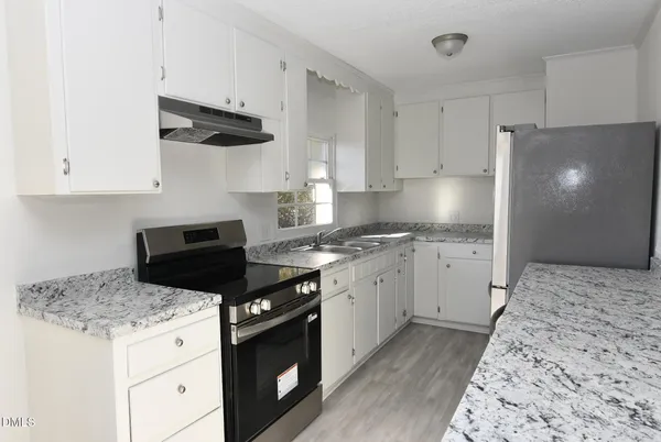a kitchen with a stove a sink and a refrigerator