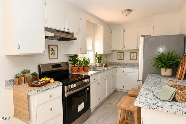a kitchen with stainless steel appliances granite countertop a stove a sink and a refrigerator