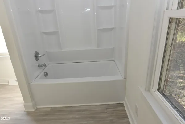 a white bath tub sitting next to a window