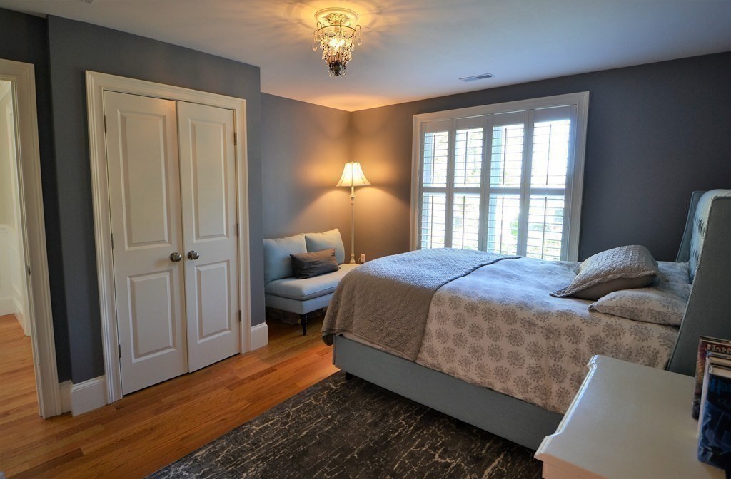 11 Tufts Road, Unit 11 Winchester, MA 01890 - Photo 11 of 18 a bedroom with a bed and a chandelier